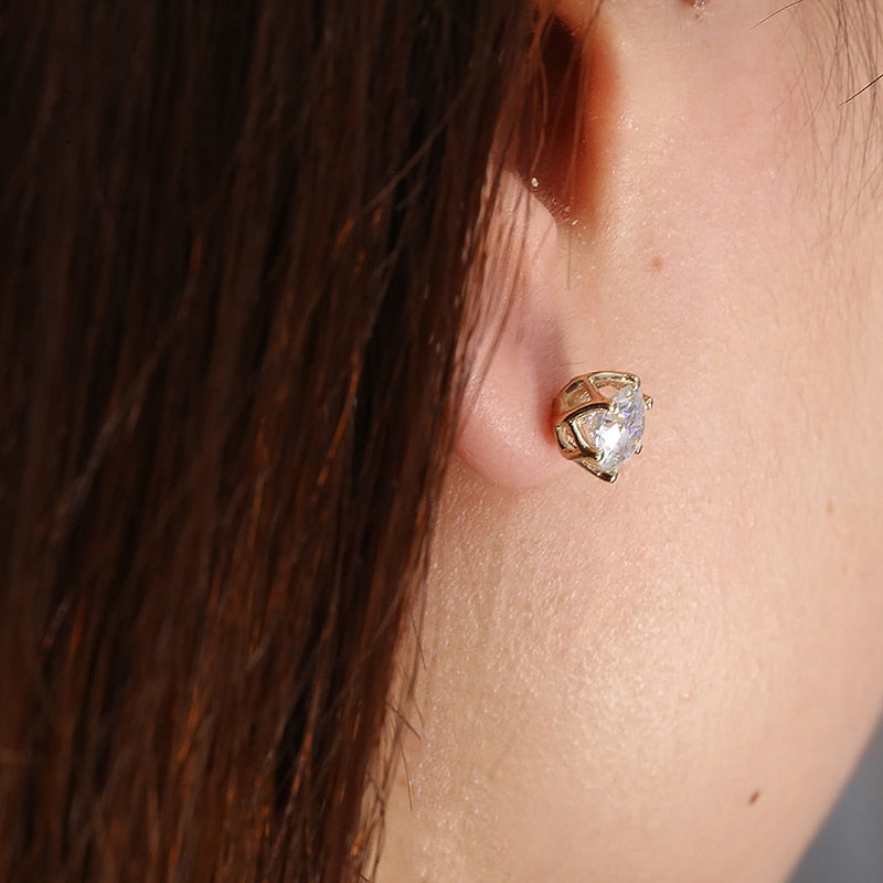 A silver moissanite stud earring being worn.