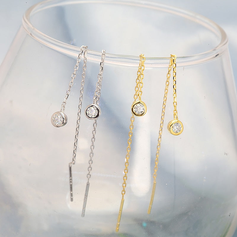 A gold pair and silver pair of chain dangle earrings bezel set with moissanite.