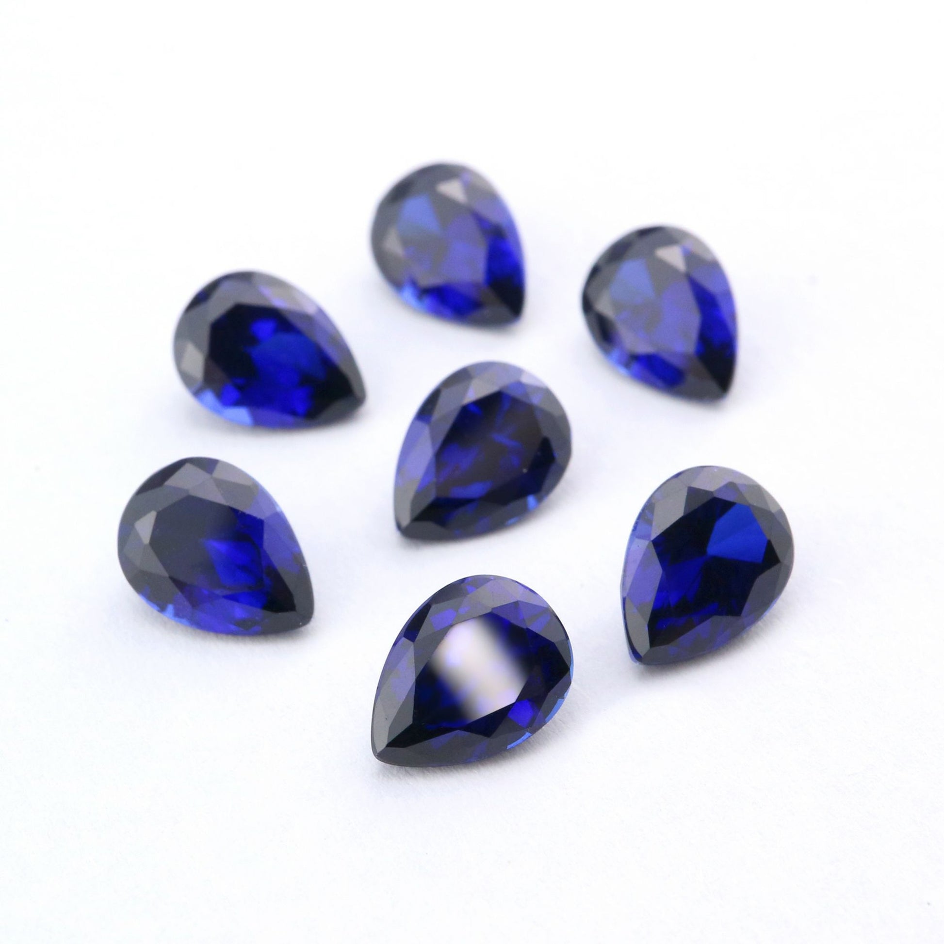 Seven tear drop cut dark blue lab created sapphire.