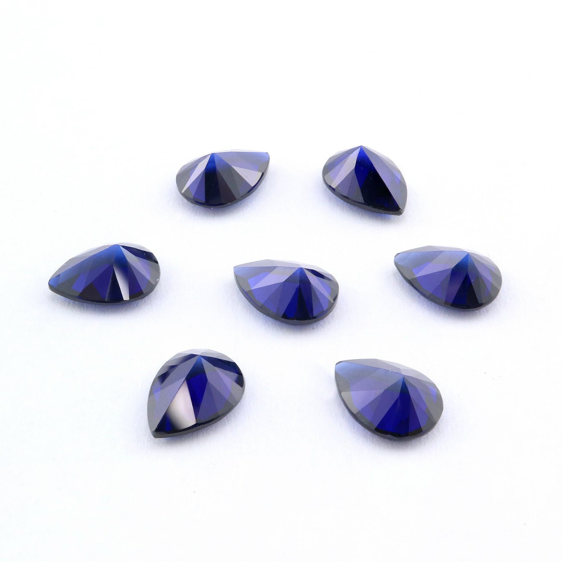 Seven tear drop cut dark blue lab created sapphire.