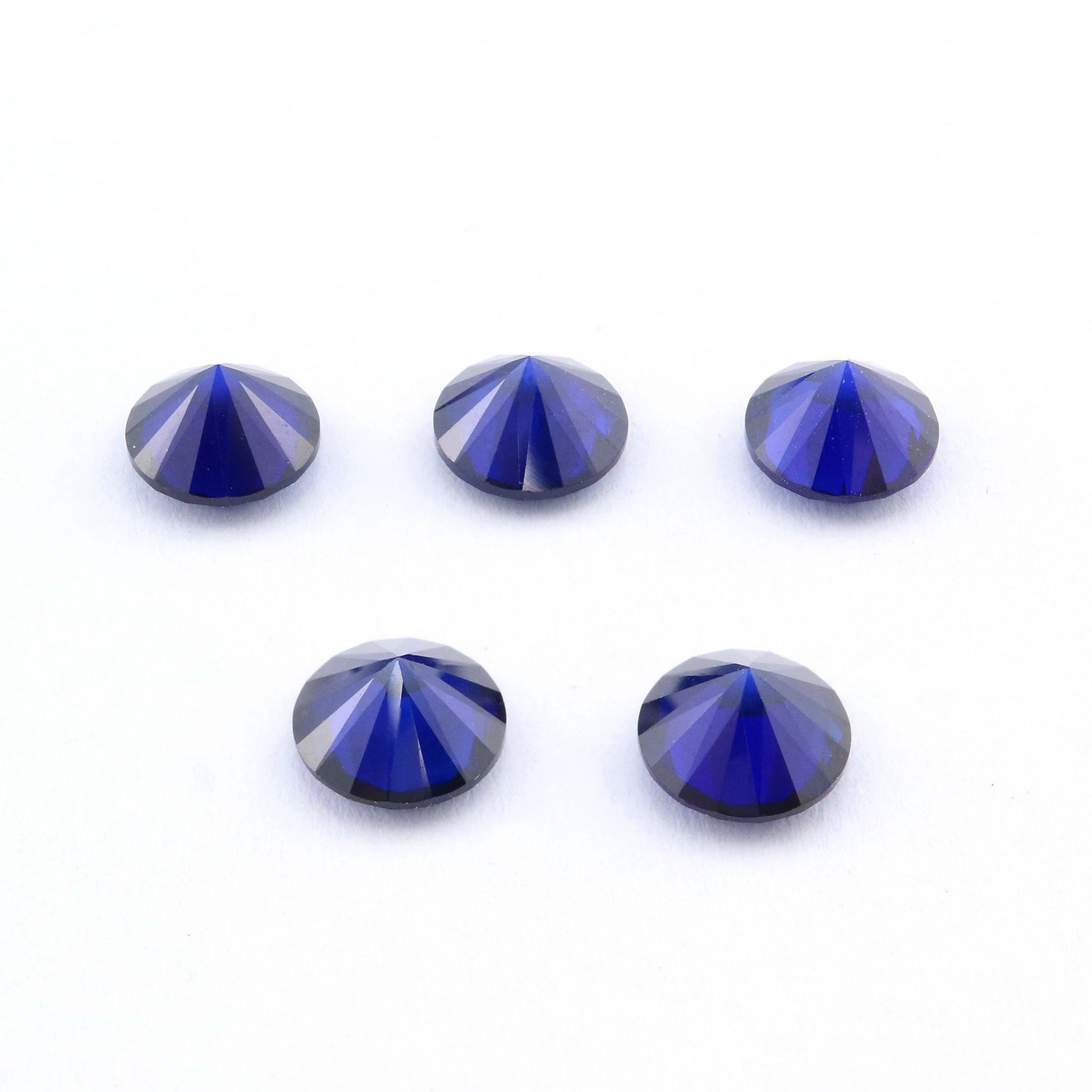 Five dark blue round cut lab created sapphire.