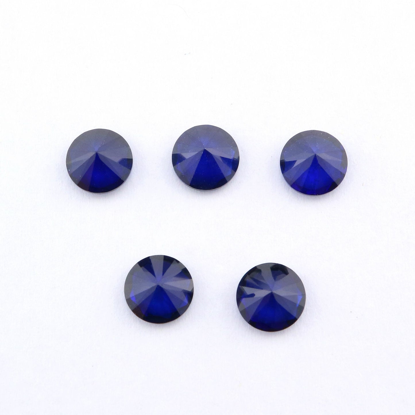 Five dark blue round cut lab created sapphire.