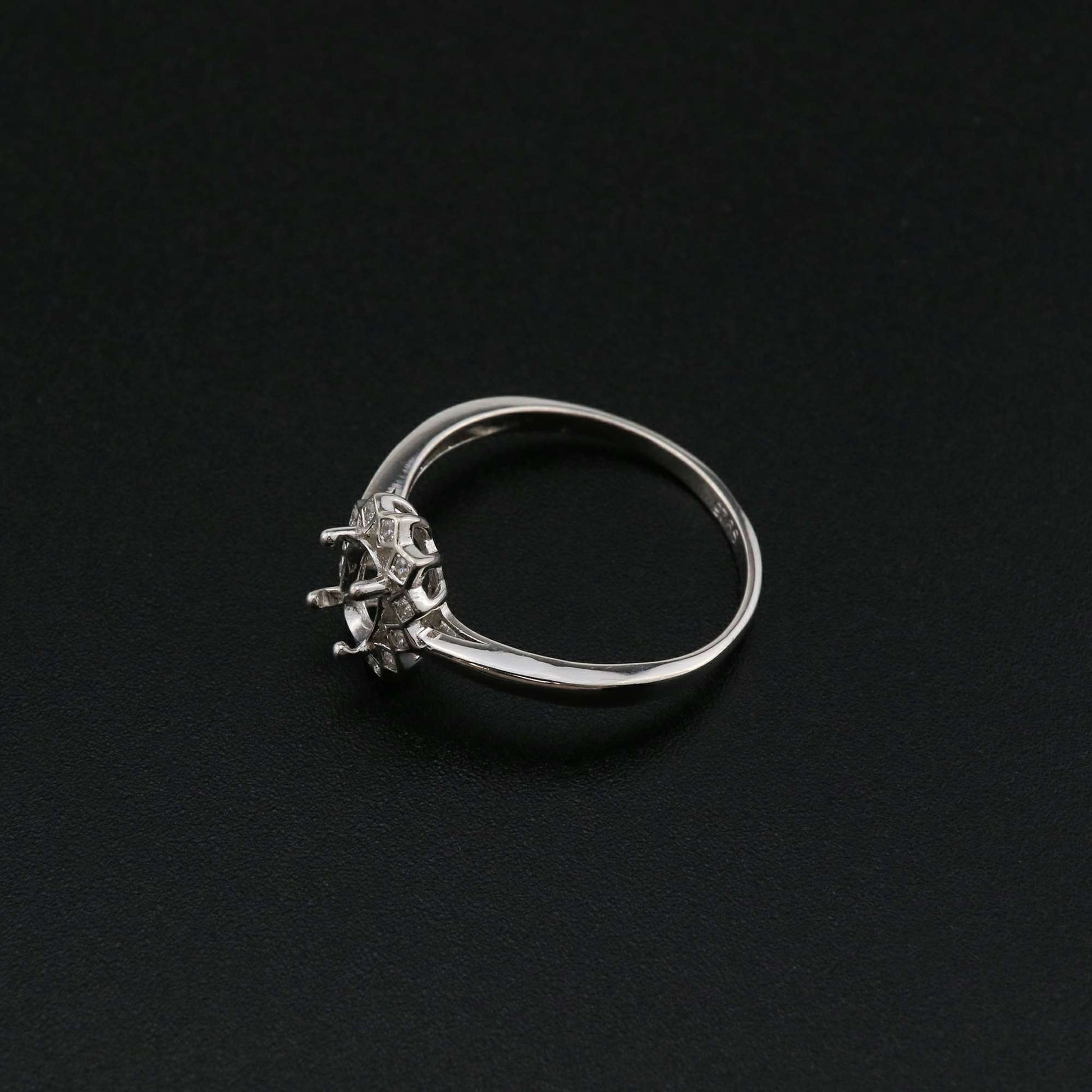 A silver semi mount with a halo of squared bezel set gems.