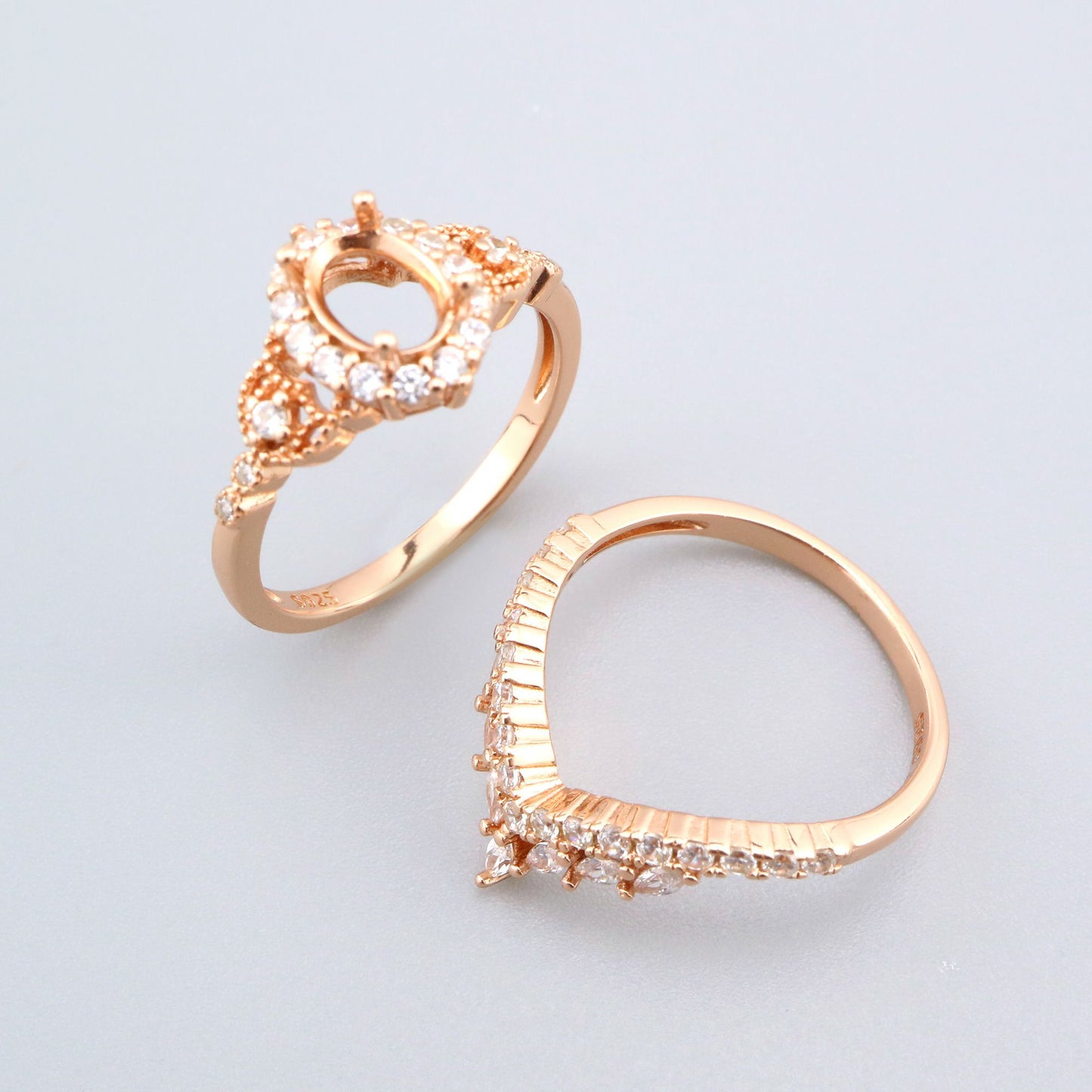 A rose gold oval halo with extra detail and a matching chevron wedding ring.