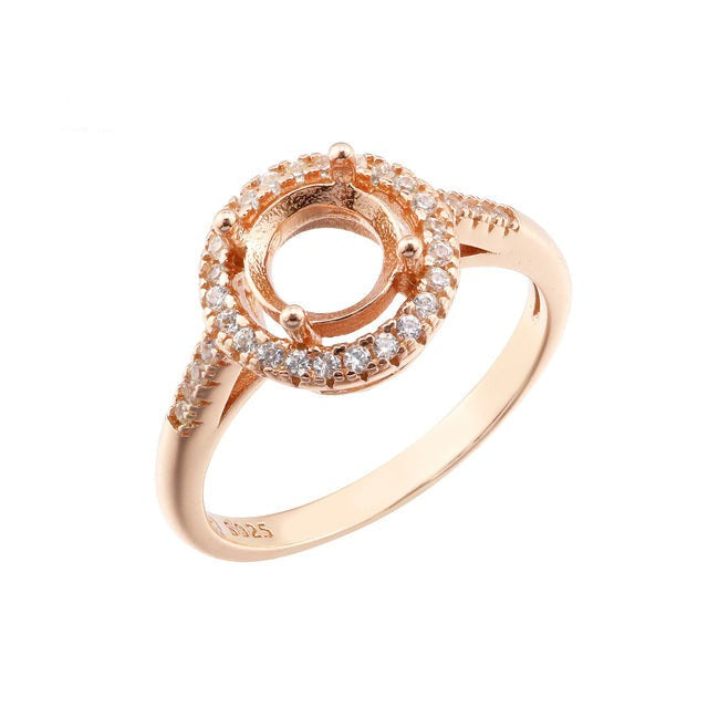 A rose gold round halo semi mount.