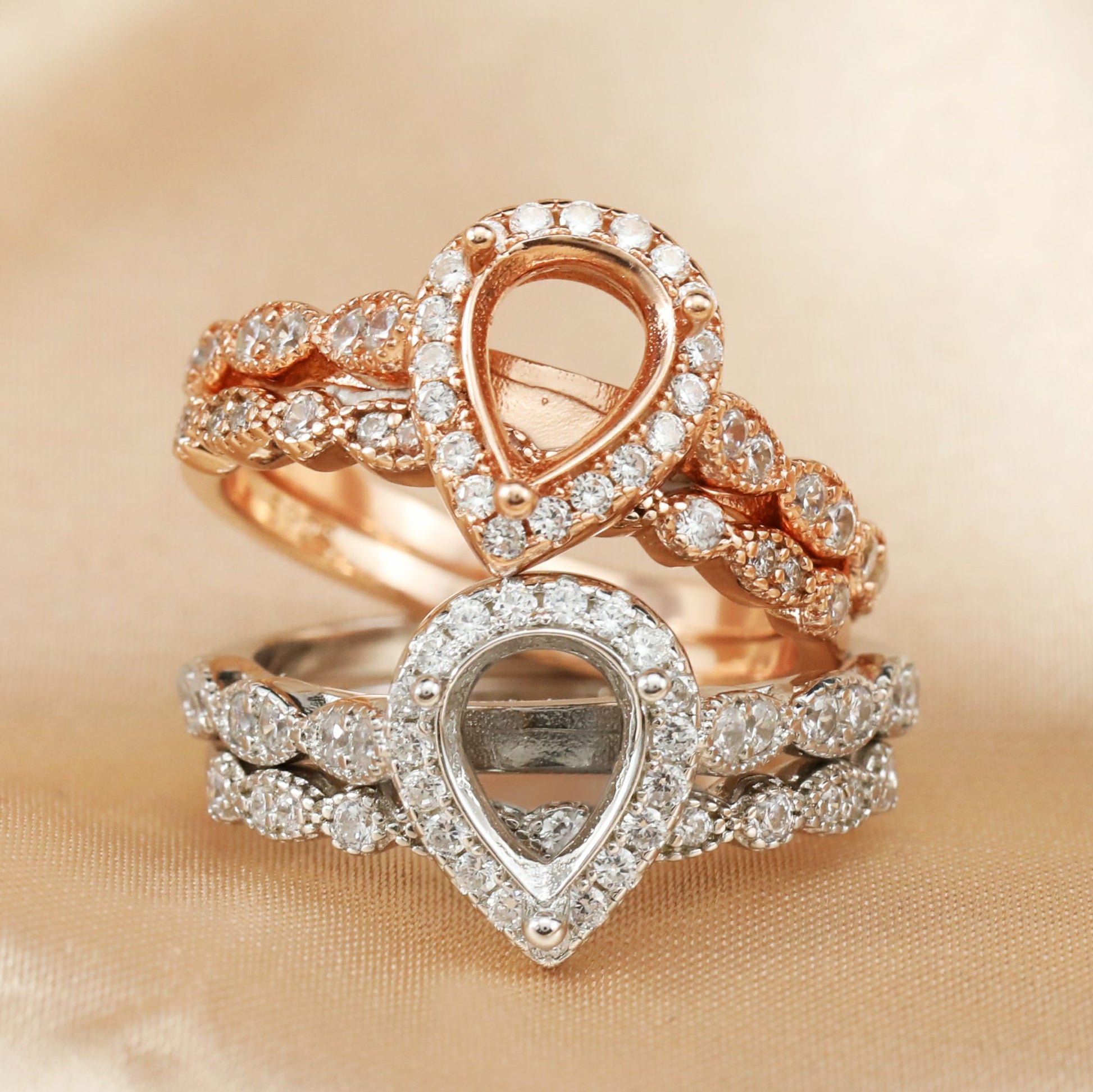 A silver art deco tear drop halo semi mount setting with matching wedding ring and a rose gold identical setting.