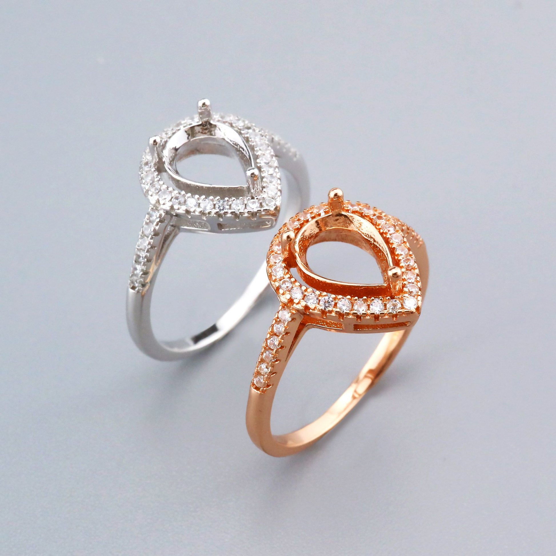 One silver and one rose gold tear drop shaped halo semi mount settings.