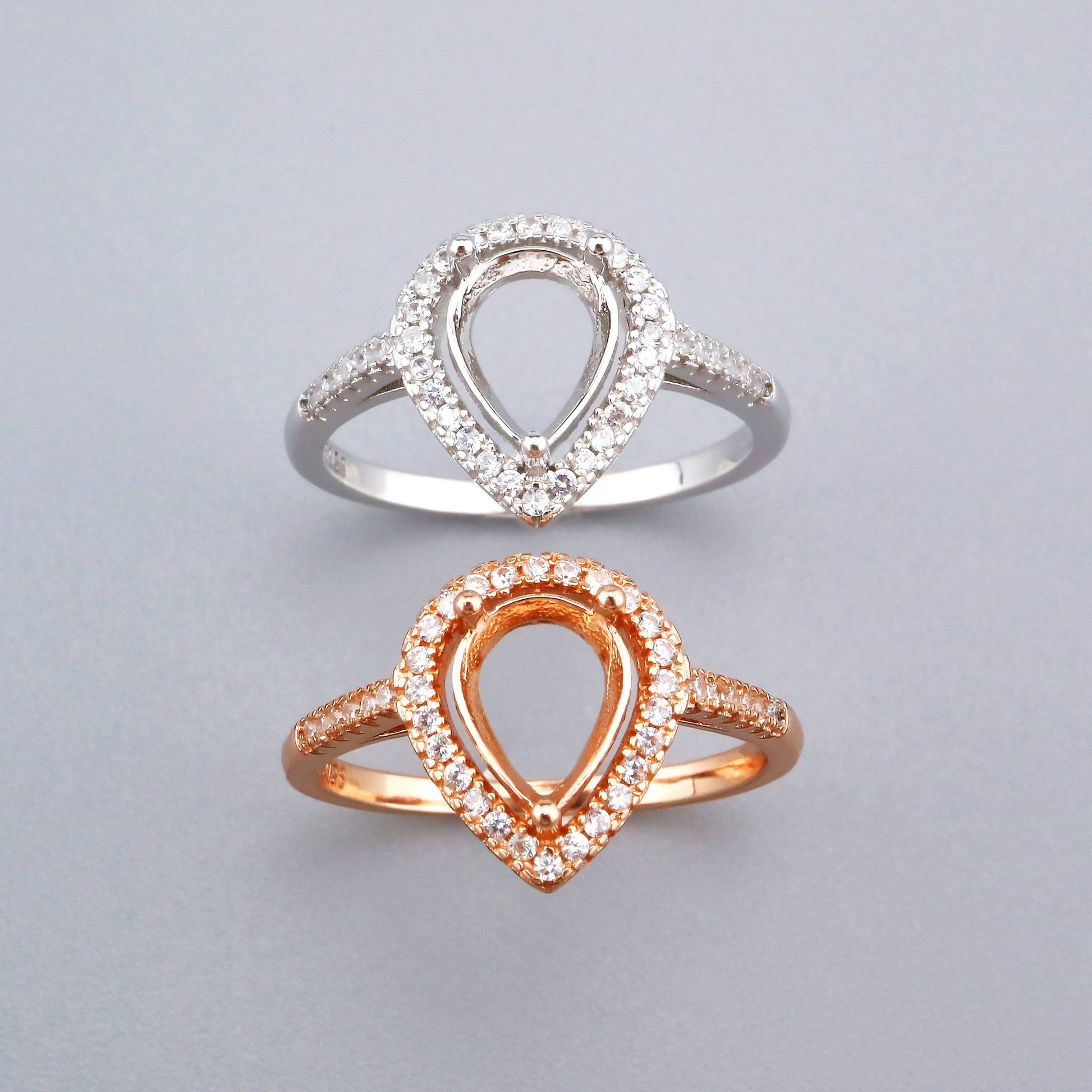 One silver and one rose gold tear drop shaped halo semi mount settings.