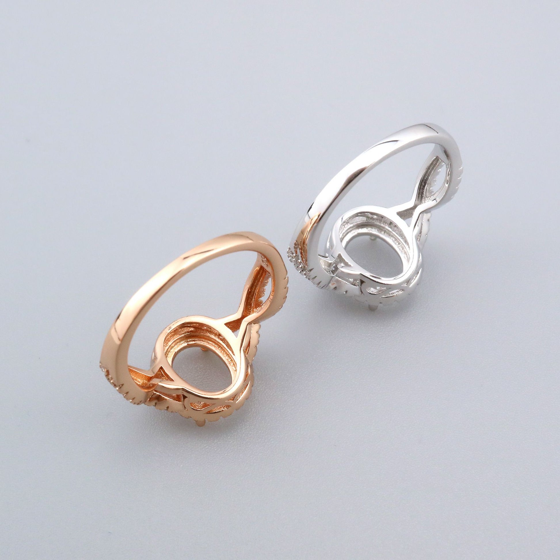 One silver and one rose gold split shank, twisted oval halo semi mounts.