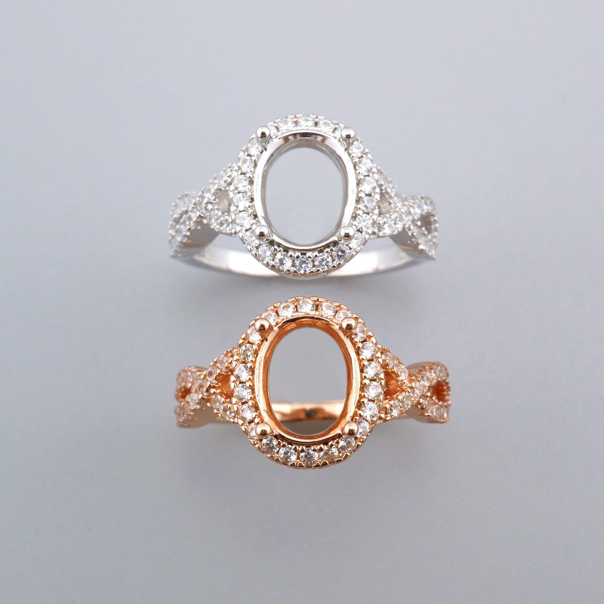 One silver and one rose gold split shank, twisted oval halo semi mounts.