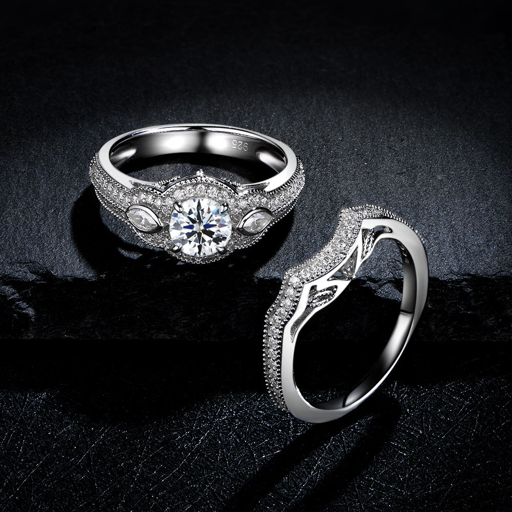 A silver iced out filigree engagement ring and matching curved wedding ring.