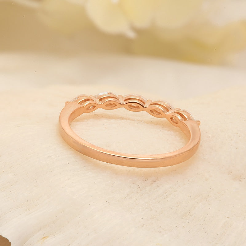 A rose gold half eternity band set with five marquise cut moissanites.