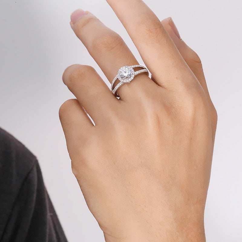 A hand wearing a silver round cut double band split shank ring.
