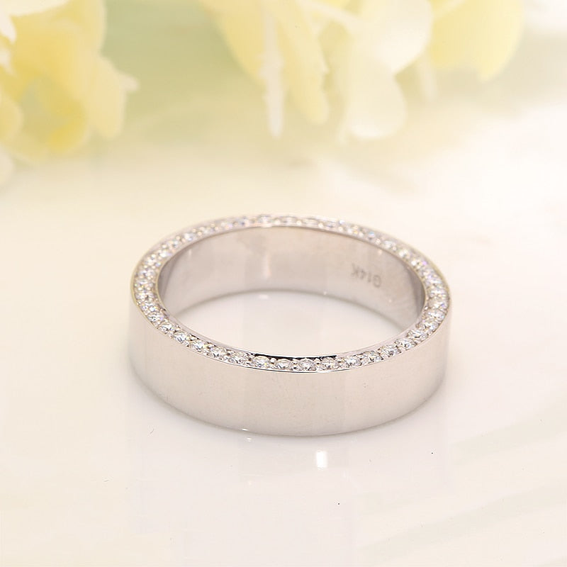 A silver thick wedding ring with moissanite encrusted sides.
