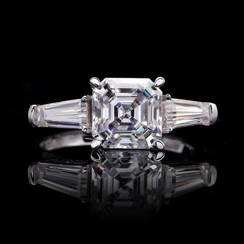 A silver 3 stone ring set with a Ascher cut moissanite nestled between two baguette moissanites.