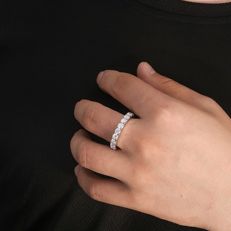 A hand wearing a silver full eternity wedding ring.