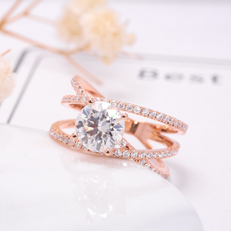 A rose gold pave triple banded ring set with  round moissanite in the center.