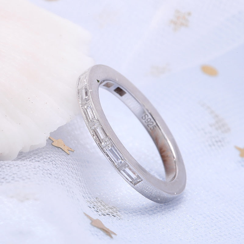 A silver wedding ring channel set with 9 baguettes horizontally.