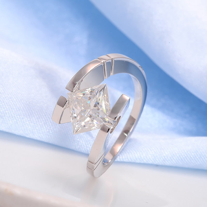 A silver ring bypass and tension set with a princess cut moissanite.