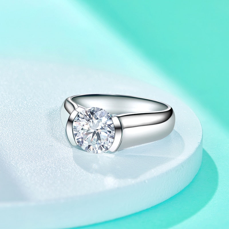 A white gold plated round cut moissanite tension set in a floating half bezel setting.