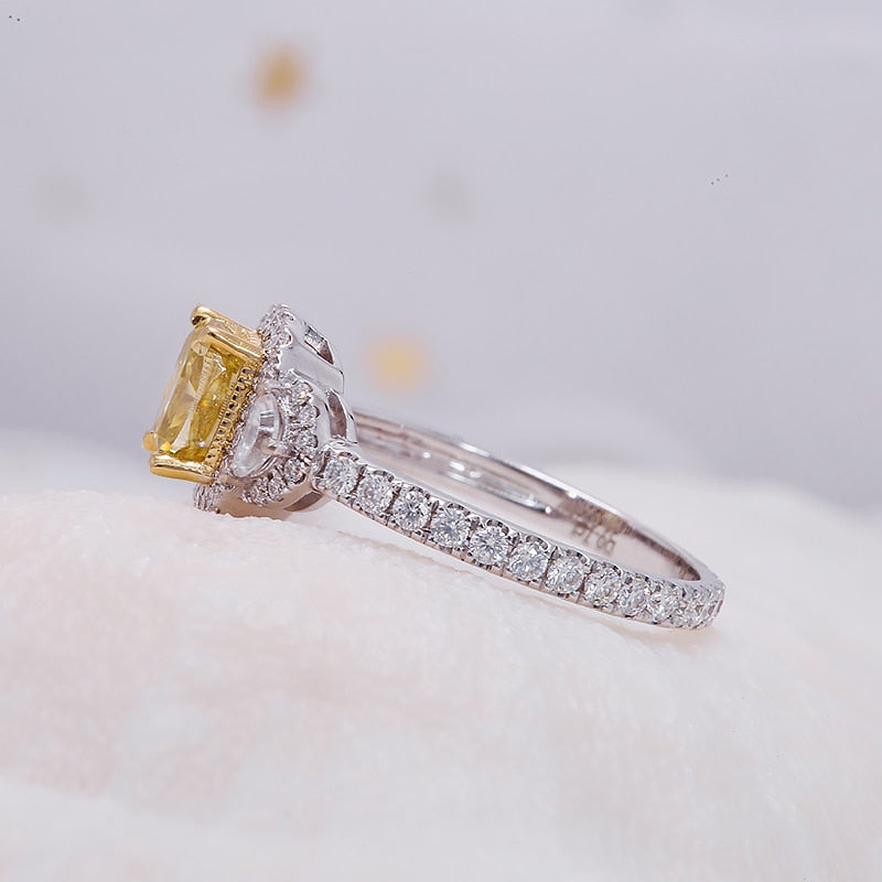 A silver halo ring set with a yellow moissanite and two crescent halo clear moissanites on each side.