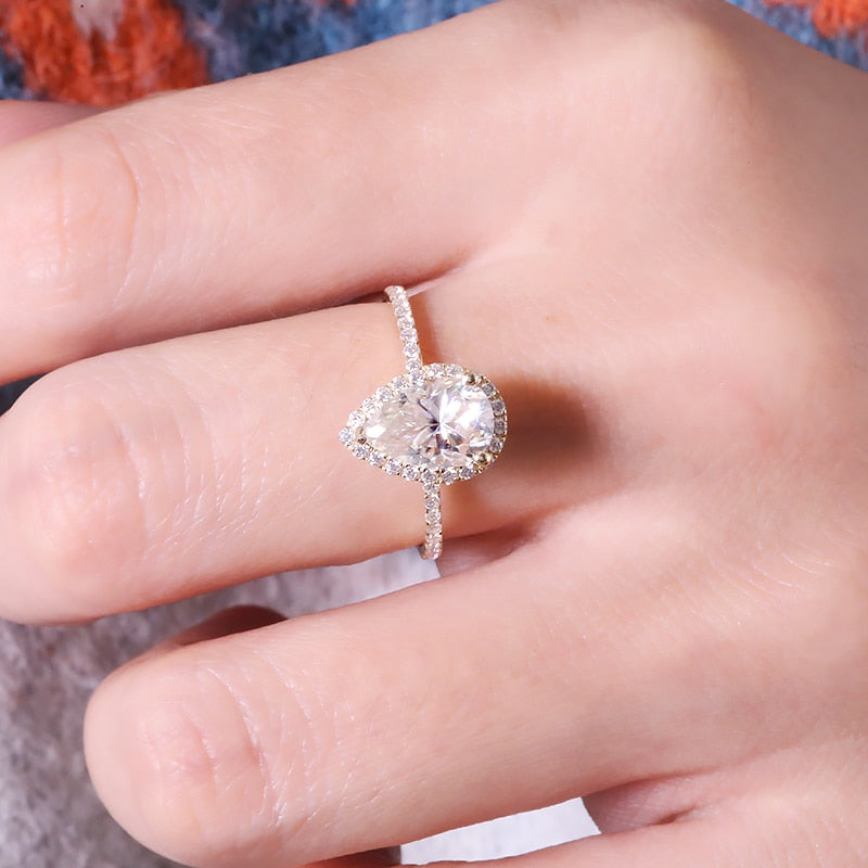 Solid yellow gold tear drop cut moissanite halo engagement ring.