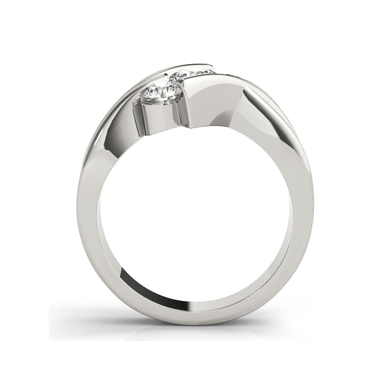 A silver 3 stone rings with moissanites tension set vertically at a diagonal angle between a triple bypass band.