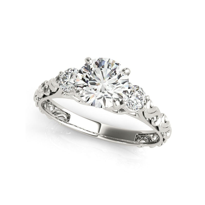 A silver filigree ring set with a 1CT moissanite and a smaller gem on each side.