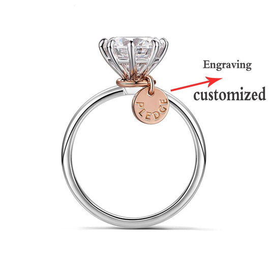 A silver round solitaire ring with a personalized rose gold name tag.