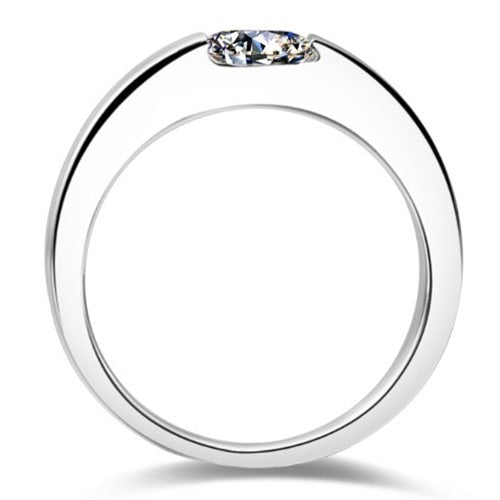 A silver thick band tension set with a round cut moissanite.
