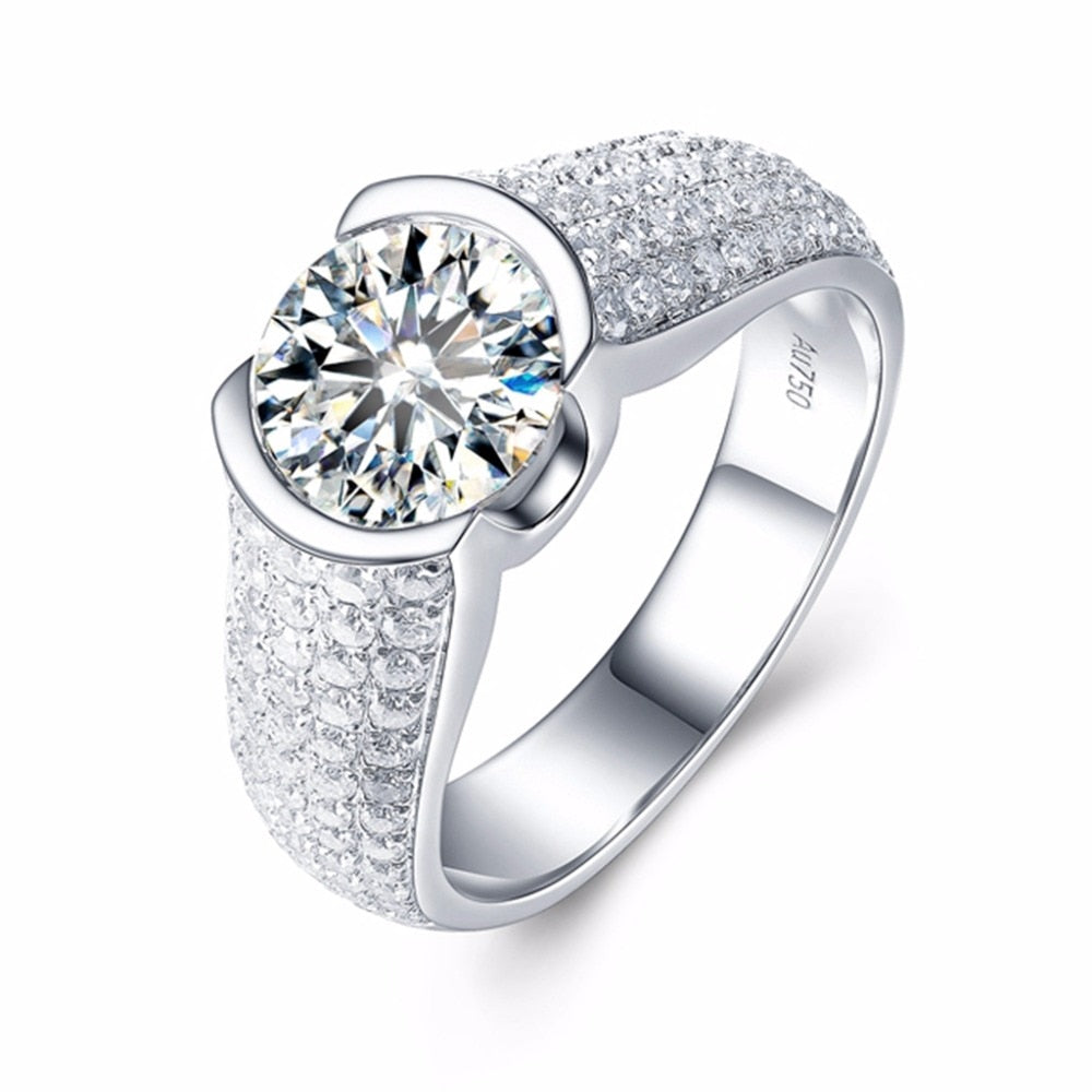 A silver ring half bezel tension set with a round 2CT moissanite and a gem encrusted thick band.