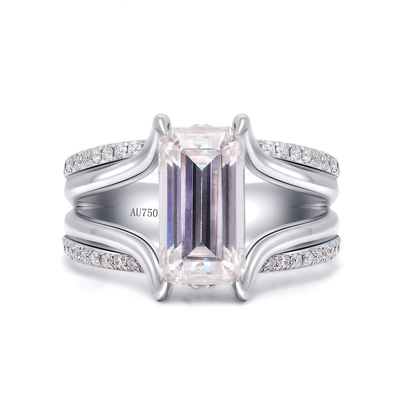 A silver split shank ring set with a 3CT emerald cut moissanite and a row of pave gems along the top and bottom band.