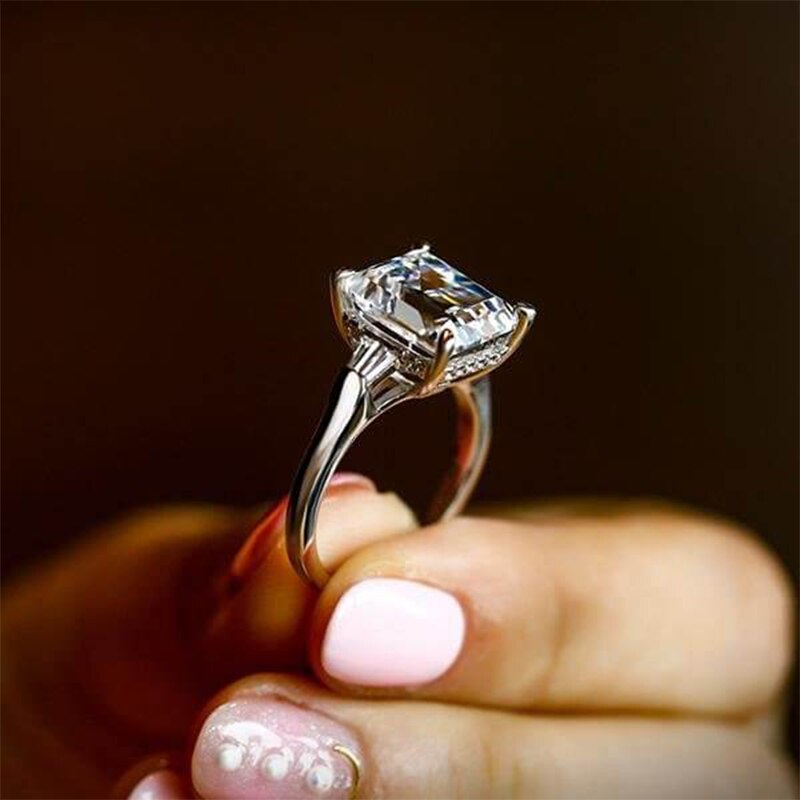A Large silver emerald cut moissanite 3 stone ring.