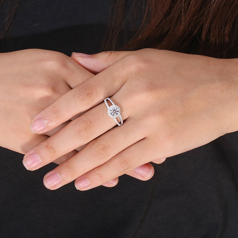 A hand wearing a silver round cut double band split shank ring.
