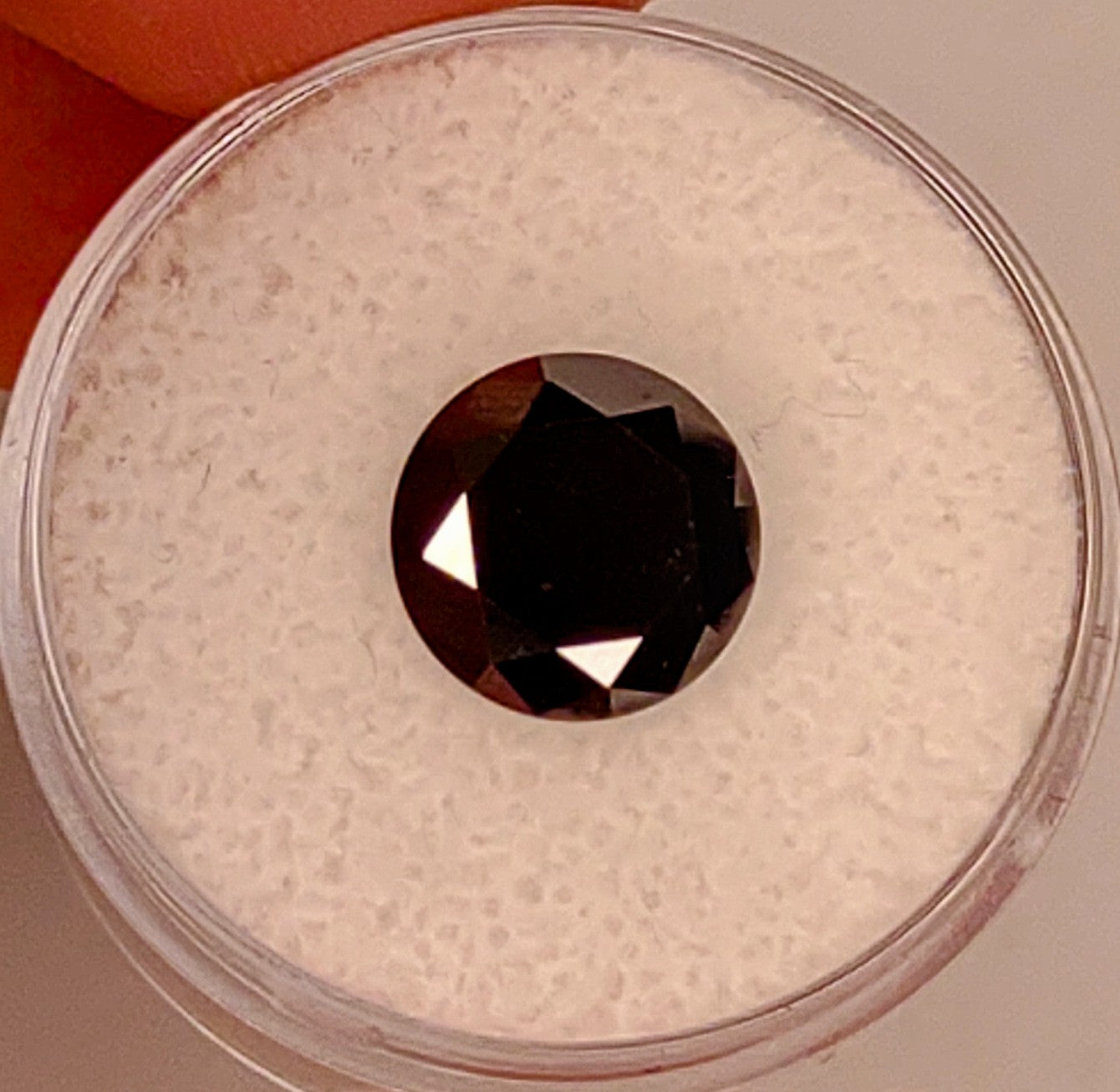 A black round cut moissanite.