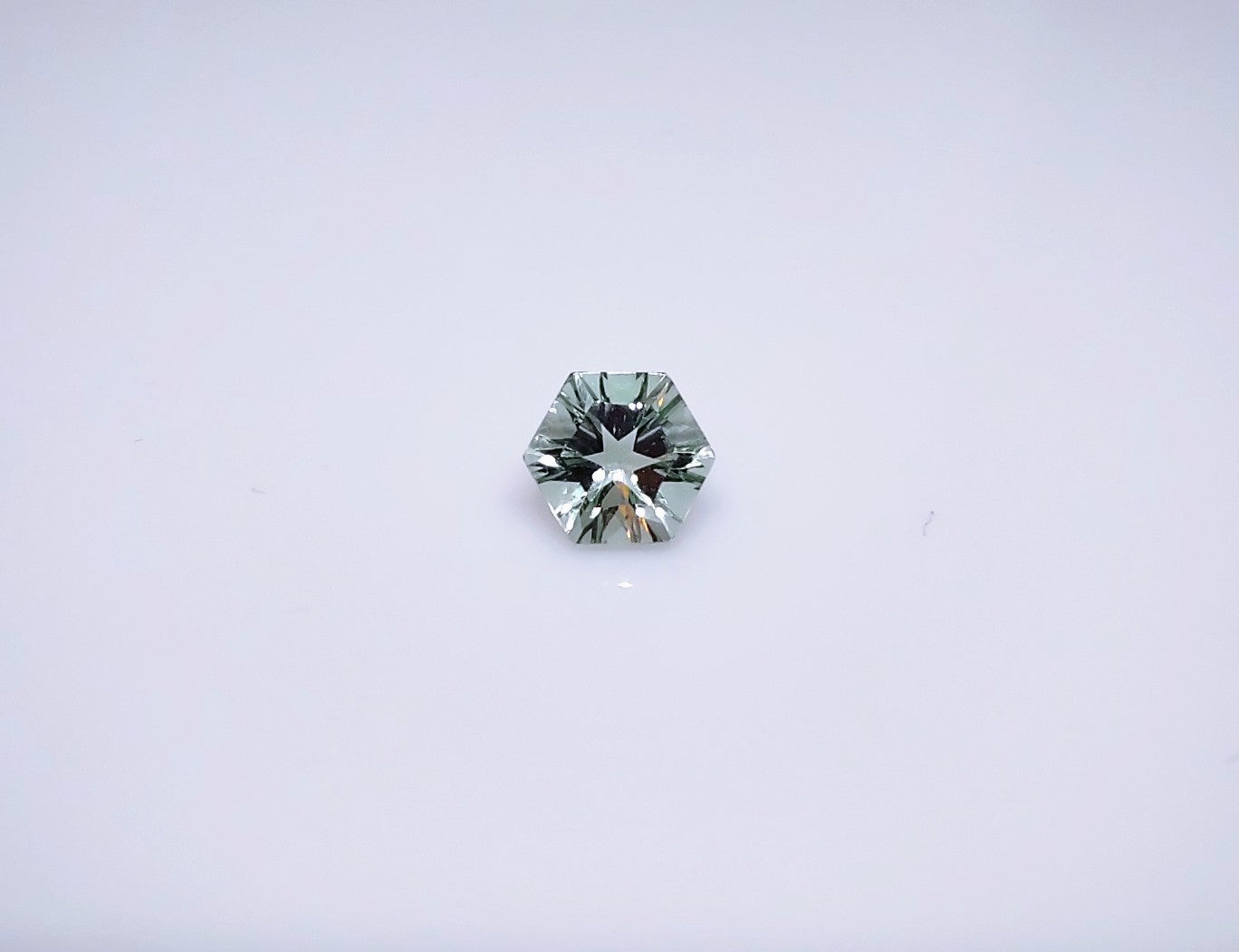 A concave cut light green round amethyst.