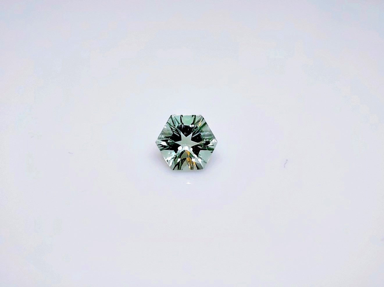 A concave cut light green round amethyst.