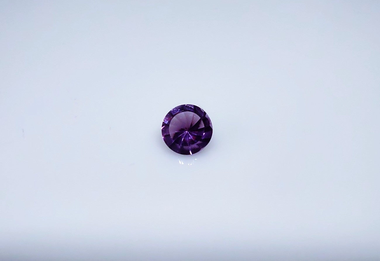 A spiral cut purple round amethyst.