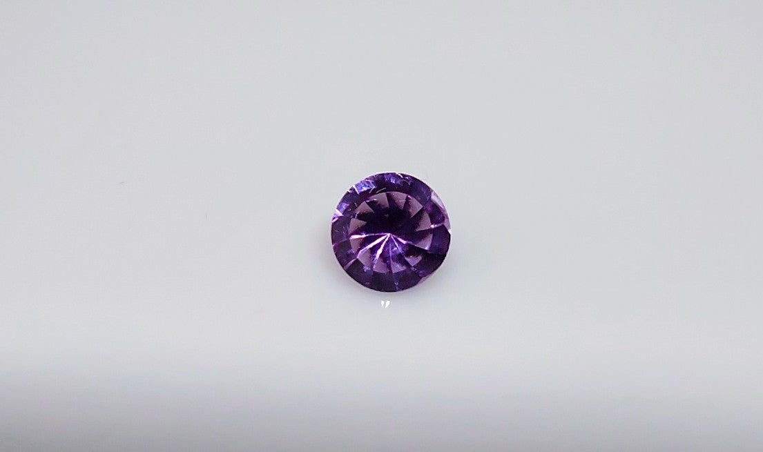 A spiral cut purple round amethyst.