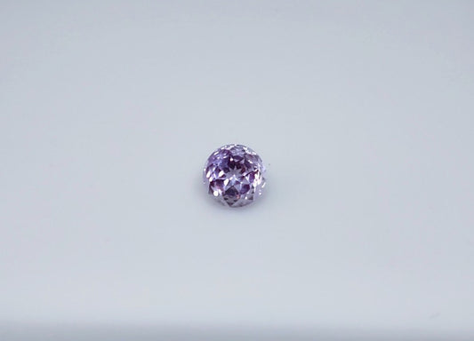A round purple amethyst with a bee hive cut.