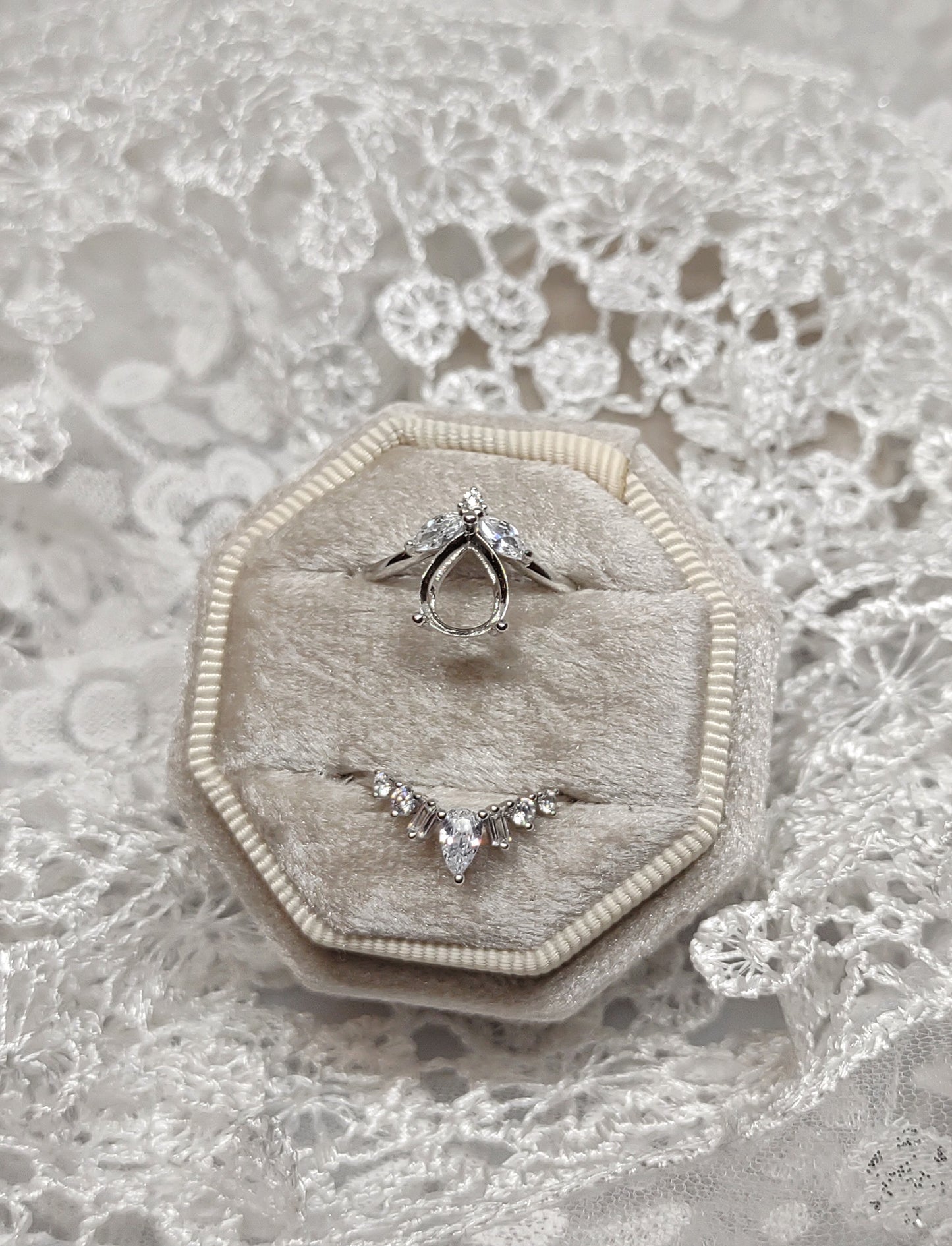 A silver pear cut semi mount with a matching chevron wedding band.