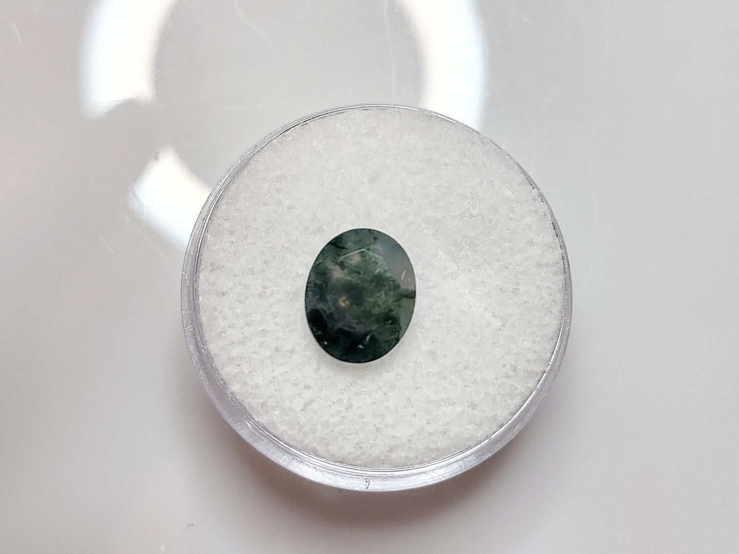 A mostly green colored oval cut moss agate.