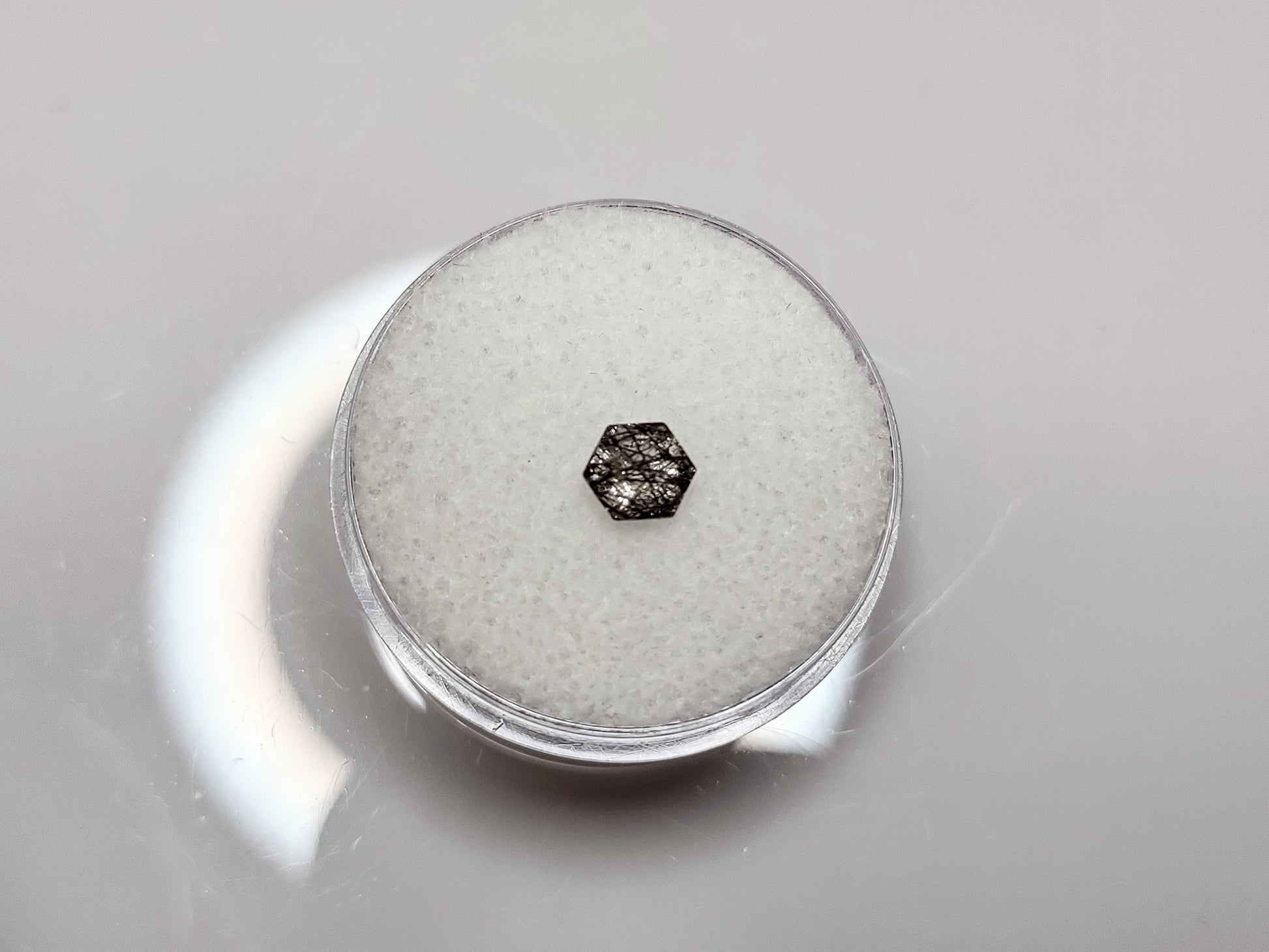 A small hexagon clear and black rutilated quartz with lots of even dispersed black streaks.