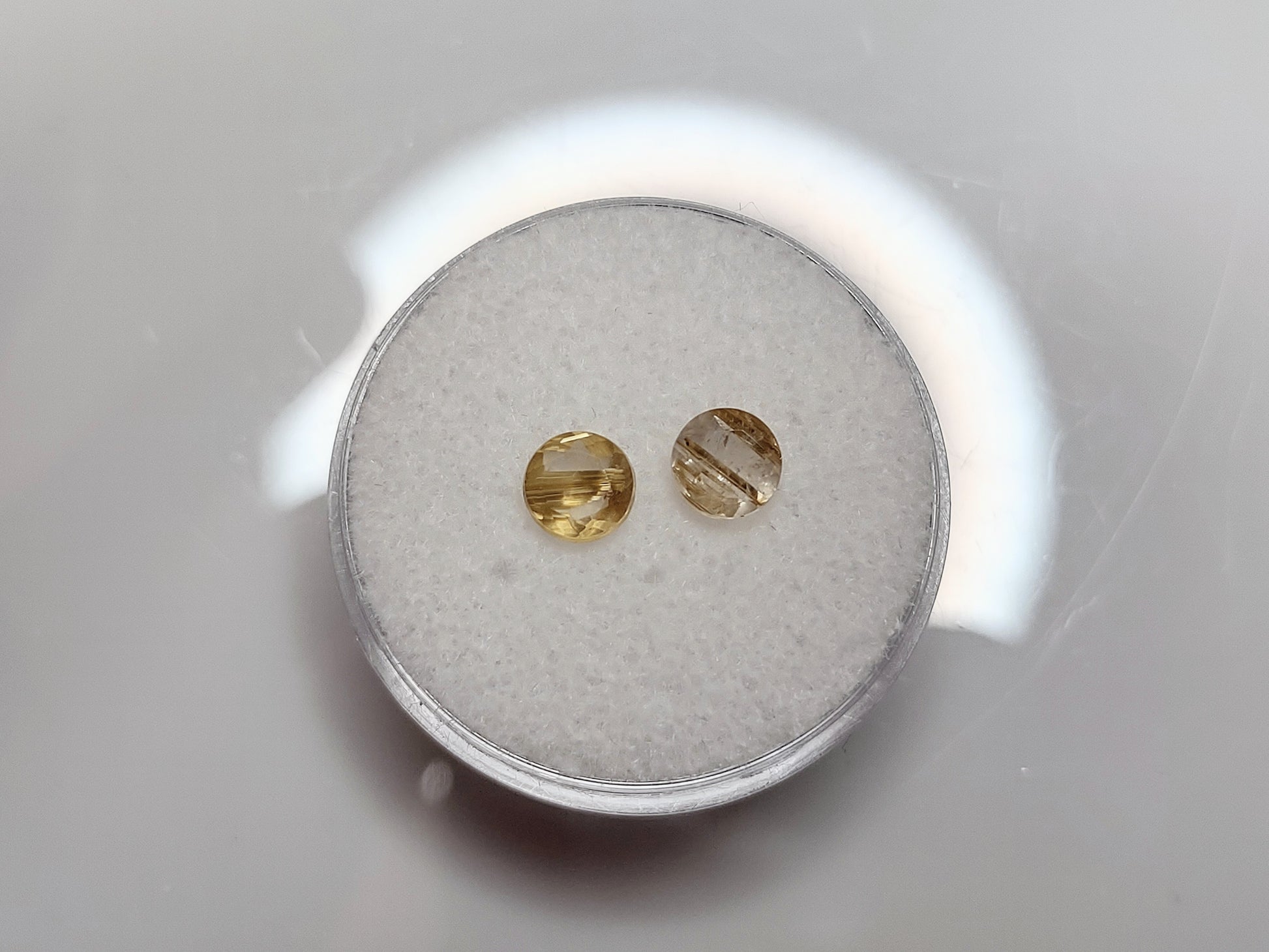 Two small clear quartz stones with golden stripes in it.