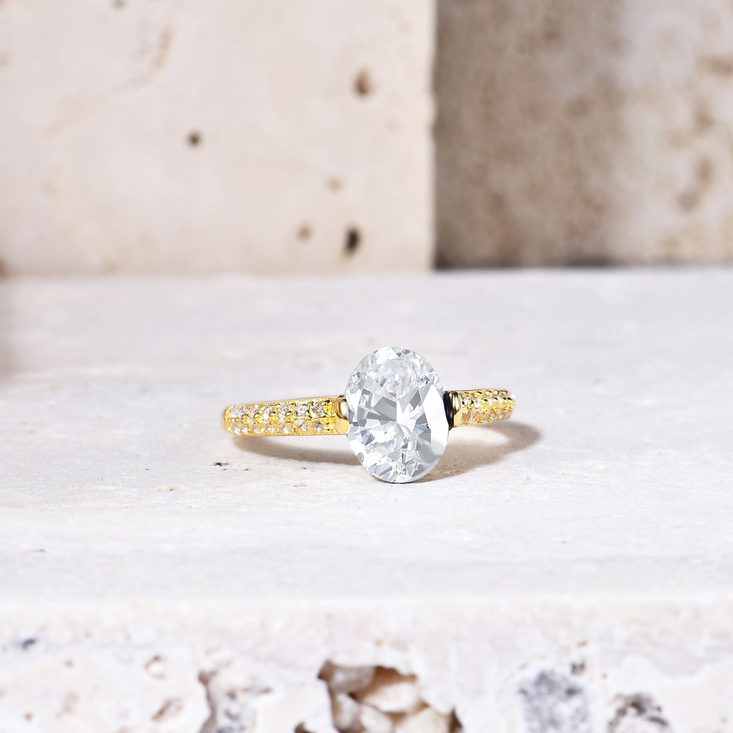 A gold tension set ring with a oval moissanite and double row pave band.