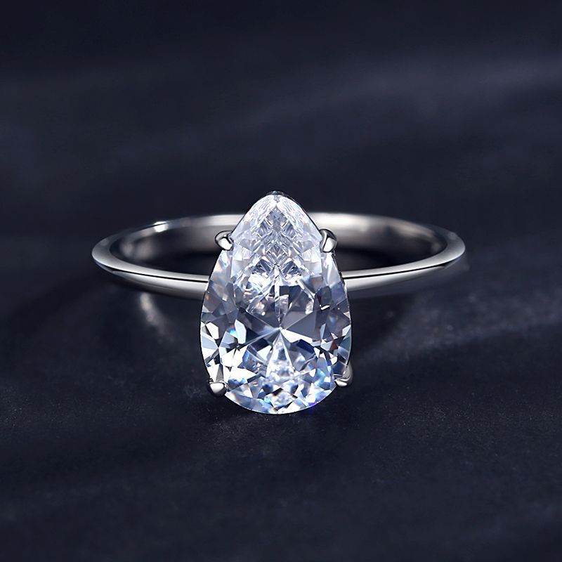 A silver solitaire ring set with a large pear cut moissanite. 