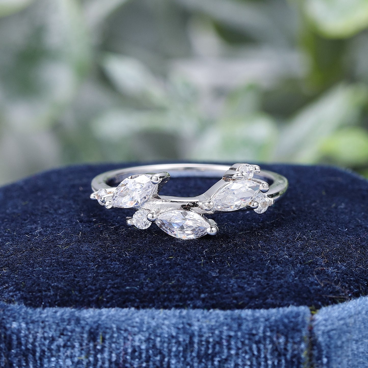 A silver wedding ring with three marquise moissanite set like leaves.