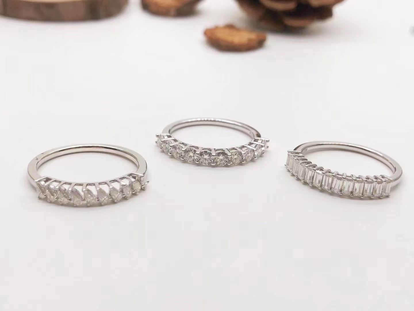 3 Silver wedding rings set with several vertical pear, round and emerald cut clear gems.