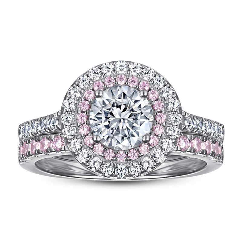 A silver double halo pink and white halo ring set with a round cut moissanite and with a matching pink eternity ring.