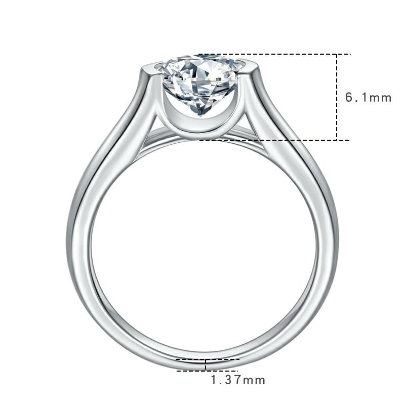 A silver bezel tension set round moissanite on a thick shank.